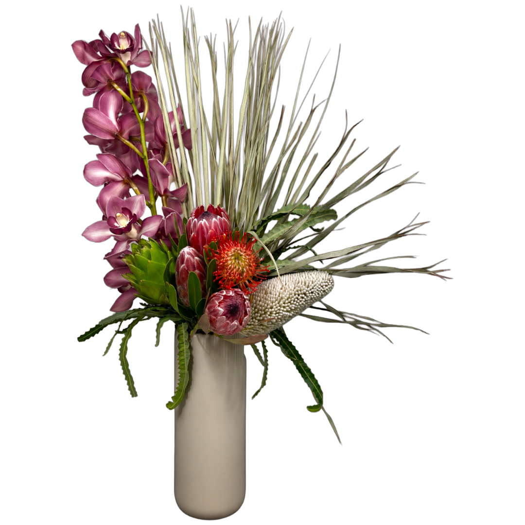 Burgundy orchids, red proteas and a sculptural palm in a tall neutral vase